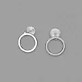 Minimalist silver hollow circular stud earrings with silicone backs on grey background - Round / Silver