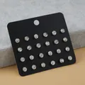 Detail von 12 Paar funkelnden runden Zirkonia-Ohrsteckern auf schwarzem Displaykarton - Weißer Zirkonia Runder Stil (FX1009)