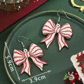 Christmas bow drop earrings with red stripes and green dots in holiday setting - Red White Striped Bow (SD61381)