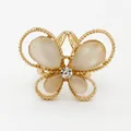 Gold butterfly ring with white opal wings and central rhinestone on white background - Gold Butterfly Pearl