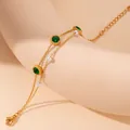 Double-layer gold chain bracelet with emerald green stones and pearls on beige prop - Pearl Round Green Zirconia Style