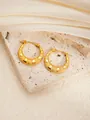 Detail of gold titanium hoop earrings with textured star patterns on beige stone and silk - Round E0264 Style