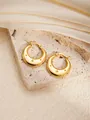 Detailed macro view of 18K gold-plated star engraved thick hoop earrings on satin - Round E0259 Style