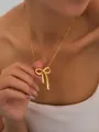 Close-up of elegant gold bow pendant necklace with pearl on woman's neck - Pearl Bowknot Necklace