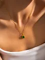 Dettaglio della collana dorata con ciondolo rettangolare verde smeraldo sulla clavicola - Catena a Smeraldo (Placcato Oro)