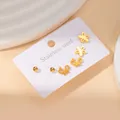 Detailed view of three pairs of golden stainless steel stud earrings on a card - Ball Butterfly Flower Style Set (BJGE0308)