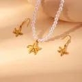 Maritimes Schmuckset mit Perlenkette und goldenem Seestern Anhänger auf warmem Sand - Seestern (Halskette Und Ohrringe)