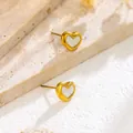 Elegantes pendientes de corazón dorados con incrustación blanca sobre fondo de piedra natural - Pendientes de oro
