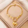 Goldenes Edelstahl-Herzarmband mit U-Link-Kette auf beigem Schmuckdisplay - Herz Armband