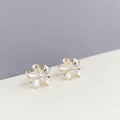 Dettaglio di orecchini a fiore con petali di perla e strass iridescenti dorati - Bianco (E715)