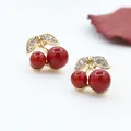 Close-up of gold cherry stud earrings with red beads and leaf-shaped crystal accents - Gold (A9309)