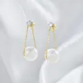 Dettaglio di orecchini lunghi in oro con perle e perni con zirconi trasparenti brillanti - Stile Catena di Perle Oro