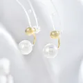 Dettaglio ravvicinato di orecchini di perle placcati in oro con perle traslucide su supporto - Perla Dorata