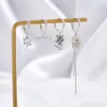 Silver earring set featuring heart stone, tassel chain, and lucky tiger charms - Silver