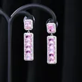 Vista macro di lunghi orecchini a pendente in argento con zirconi rosa incastonati - Argento Rosa