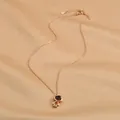 Dettaglio ravvicinato della collana astronauta oro rosa su elegante tessuto in seta champagne - Oro Rosa (XL62410)