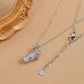 Close-up of a silver coffee cup pendant with white crystals and a heart-shaped charm - Silver