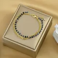 Dettaglio del bracciale a doppio strato con catena barbazzale dorata e perle nere - Oro Nero