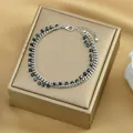 Dettaglio del bracciale a catena argento a doppio strato con perline nere su scatola oro - Argento Nero