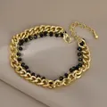 Dettaglio del bracciale a doppio strato con catena barbazzale dorata, perline nere e chiusura - Stile Perline Nere in Metallo Dorato (SL89354)