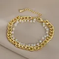 Dettaglio del bracciale a doppia catena dorata con perle bianche su seta morbida - Stile Perline Bianche in Metallo Dorato (SL89354)