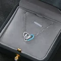Dettaglio macro del ciondolo a cuore asimmetrico con smalto blu e pietra zircone - Argento