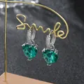 Dettaglio macro degli orecchini a cuore in zircone verde con montatura micro-pave argento - Argento Verde