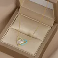 Dettaglio della collana con pendente a cuore dorato con smalto blu e zirconi in un cofanetto - Oro