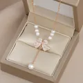 Elegante collana in oro rosa con ciondolo a fiocco, diamanti e perle a goccia - Oro rosa