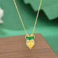 Detail of gold plated carrot necklace with zircon stones on a dark wood display - Carrot Style (XL62769) / Gold