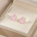 Vue macro de boucles d'oreilles cœur en zircon rose avec sertissage à griffes en or 18K - Or Rose