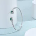Dettaglio ravvicinato di un bracciale aperto in argento con zircone verde in castone geometrico - Verde Argento
