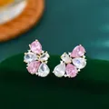 Dettaglio macro di orecchini a petalo rosa con pietre a goccia su velluto verde - Oro Rosa
