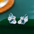 Dettaglio macro di zirconi blu chiaro e bianchi su orecchini a lobo a forma di petalo - Blu argento