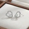 Makroaufnahme silberner Herz-Ohrstecker mit Zirkonia-Besatz in einer Schmuckschatulle - Silber
