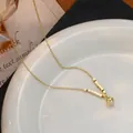 Detail van vergulde ketting met gepolijste vierkante kralen op een keramische rand - Goud (xl64463)