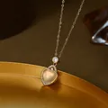 Macro shot of gold-plated heart necklace featuring a translucent chalcedony-style gemstone - Gold Style (XL68143)