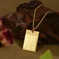 Dettaglio di un ciondolo rettangolare placcato oro con texture a onde in rilievo - Piccolo Stile Rettangolare Ondulato Oro (XL00323)