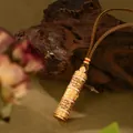 Primer plano de colgante cilíndrico dorado con carácter Fu filigranado y diamantes - Estilo Cilíndrico Filigrana Carácter Fu Diamantes (XL00327)