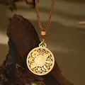 Vista macro del colgante Fu chapado en oro con diseños huecos y diamantes microincrustados - Estilo Redondo Dorado Calado Ocho Tesoros Fu (XL00332)
