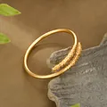 Dettaglio del bracciale dorato aperto con motivi a rilievo tradizionali cinesi su roccia - Bracciale Rigido Aperto Nuvola Fortunata Ruyi (SZ00220) / Oro