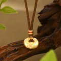 Primer plano de colgante de cerradura dorada con motivos de nubes y cordón trenzado - Estilo Cerradura Ruyi Nube Auspiciosa Oro Mate (XL00335)