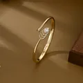 Elegant gold feather bangle with micro-pave cubic zirconia and pear-shaped stone - Gold