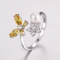 Macro detail of silver adjustable ring with butterfly zircon and white pearl accents - Silver