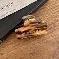 Tortoise shell pattern acetate hair claw clip with golden spring on wood surface - Textured Coffee-Pink