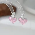 Eleganti orecchini a lobo con cuore di zircone rosa e finitura argento su supporto chiaro - Orecchini a lobo / Argento Rosa