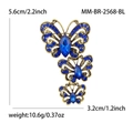 Broche papillon vintage dorée avec cristaux bleus et design d'ailes évidées - Bleu
