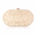 Macro detail of cream white marble texture and golden clasp on oval evening clutch bag - Champagne