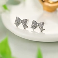 Elegant S925 silver bow knot stud earrings with sparkling pave zircon stones on a ceramic plate - Silver
