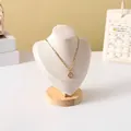 Detail of a gold letter E pendant necklace on a wooden portrait jewelry display stand - Beige Velvet Small